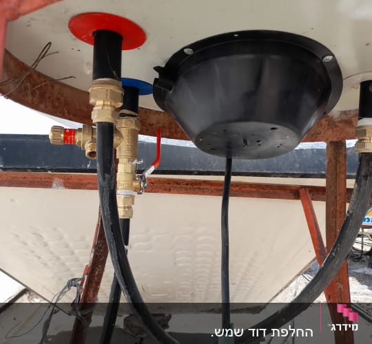 צנרת וחיבורים תחת דוד שמש על מתקן מתכת